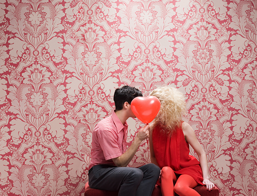Couple behind heart shaped balloon